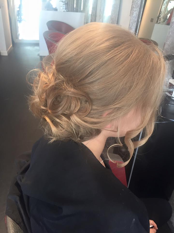 Short blonde hair softly curled and pinned to one side